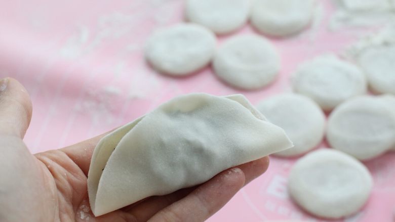 茴香馅饺子,先将饺子皮对折,然后在中间捏住