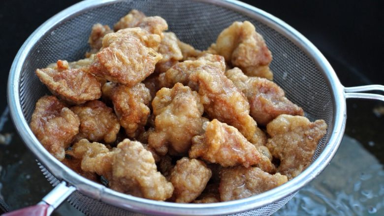 茄子溜肉段,炸至肉块表皮变硬捞出控油,然后再复炸一遍至金黄酥脆状态捞出