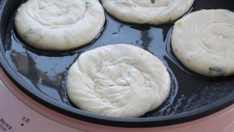 椒盐葱油饼,饼铛中放适量食用油,将饼胚依次排放锅中