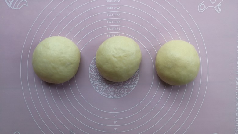 老式奶香吐司,一发后的面团倒在揉面垫上，分割成3等份后分别收圆，然后加盖保鲜膜静置松弛10分钟