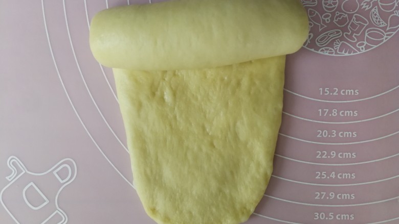 老式奶香吐司,翻面，将不光滑的面朝上，压薄底边，然后自上而下卷起