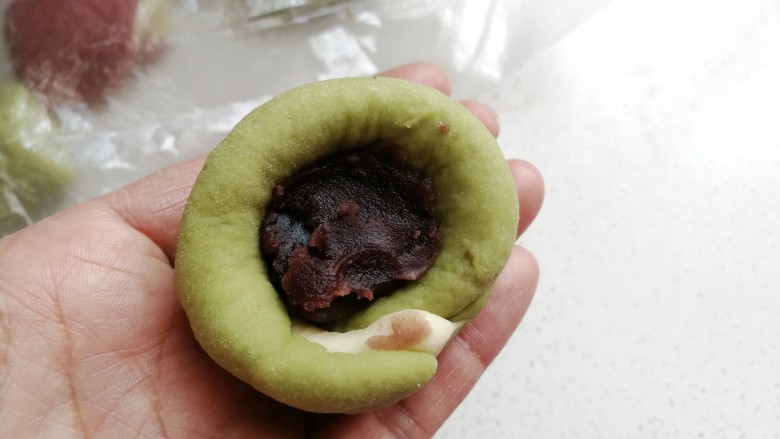 彩色风车豆沙包,再取适量豆沙馅放入窝形中,然后收口包紧。
