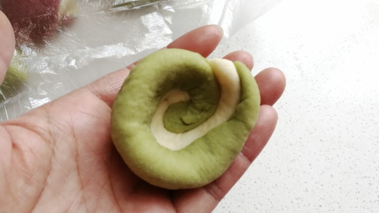 彩色风车豆沙包,然后从上向下按压,双手旋转着凹出一个窝形。