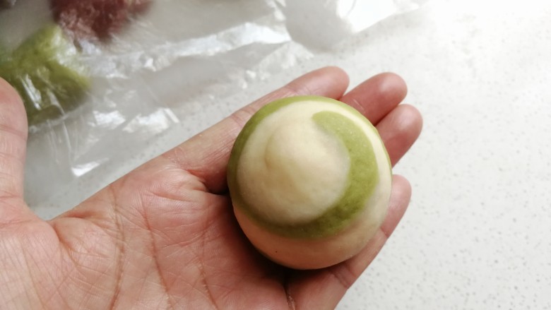 彩色风车豆沙包,包好后把它搓圆,稍微整理一下,整理成像这样的圆形。