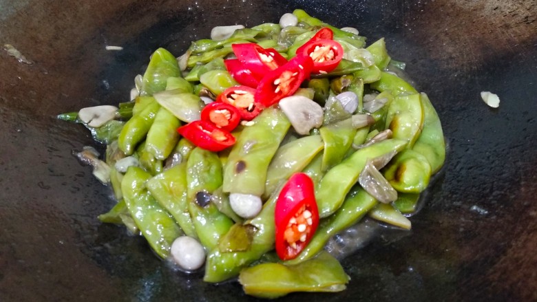 素烧橄榄豆,水烧干,到开锅盖,放入红椒翻炒半分钟。