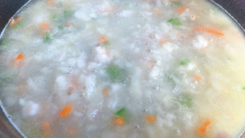 【宝宝辅食】鲜虾疙瘩汤,锅里水沸腾后,火关小一点,保持沸腾就可以,把搅拌好的面絮倒进去,左手端面碗,右手拿筷子一边搅拌一边往锅里撒