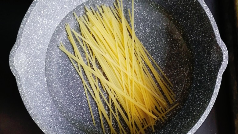 宝宝辅食—土豆鳕鱼肠炒意面,锅内倒入适量的水,放入意面煮熟捞出备用