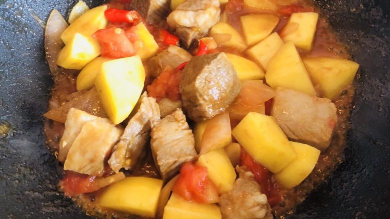 番茄土豆炖牛腩,然后放入西红柿炒软。把锅中的香葱结和姜片挑出,加入牛腩块煸炒至表面收紧,加入切好的土豆块。