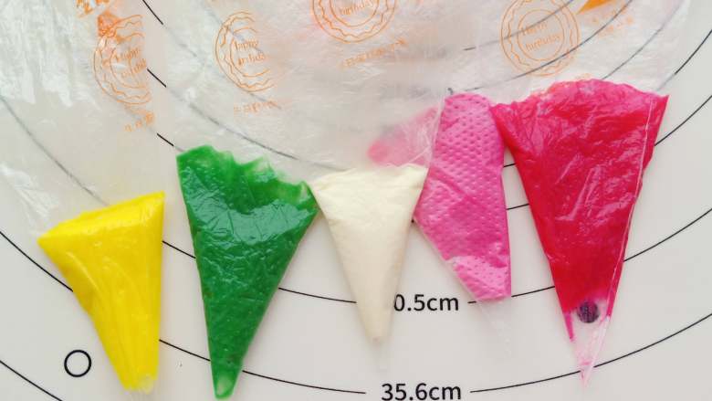 旗袍玛德琳,奶油霜用色素调出白、黄、绿、浅粉、深粉这五种颜色,装入裱花袋备用(奶油霜的制作见小贴士)