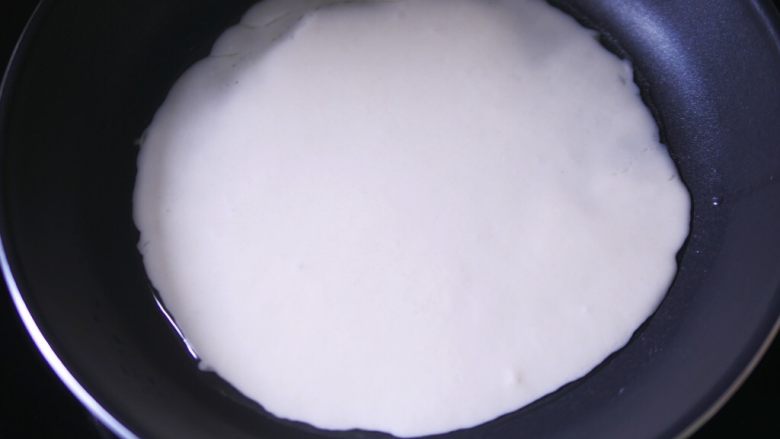 蔬菜可丽饼,舀一半面糊倒入锅中,晃动煎锅使面糊流淌均匀。剩下的面糊可以再做一份。
