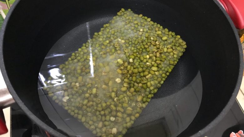 夏日解暑佳品-鲜百合绿豆汤,将绿豆冰块放入锅内,加入适量清水