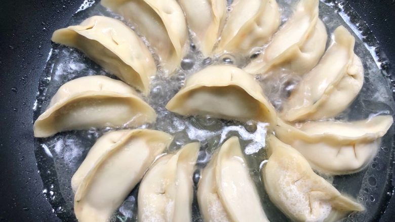 抱蛋煎饺,放入盖过饺子一半的水,盖上盖子,中火煮
