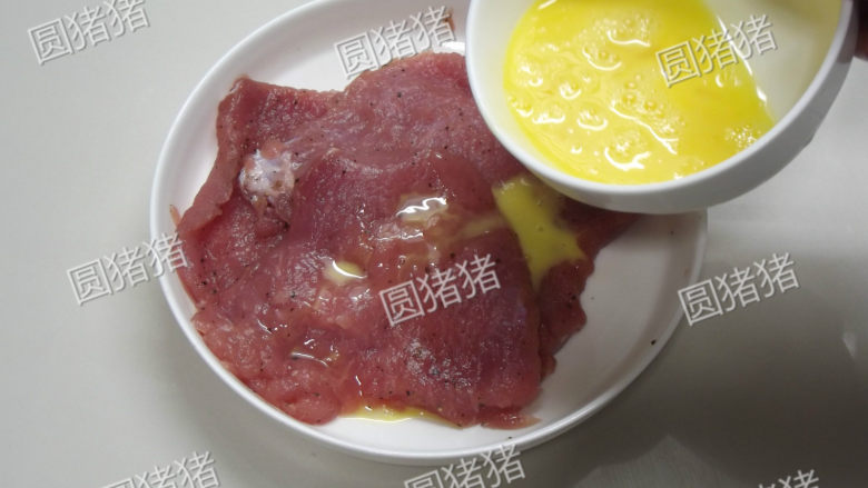 吉列猪扒,将肉用盐、胡椒粉、酒、<a style='color:red;display:inline-block;' href='/shicai/ 512'><a style='color:red;display:inline-block;' href='/shicai/ 512'>玉米淀粉</a></a>抹匀,再用2小匙的鸡蛋液抓匀腌制10分钟。