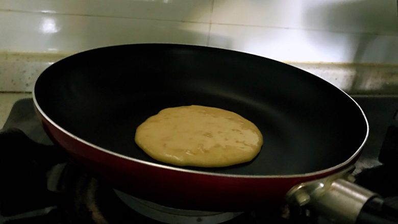 香蕉松饼的健康做法,调小火,不用放油,舀入一大勺面糊,待面糊表面起泡,即可翻面。