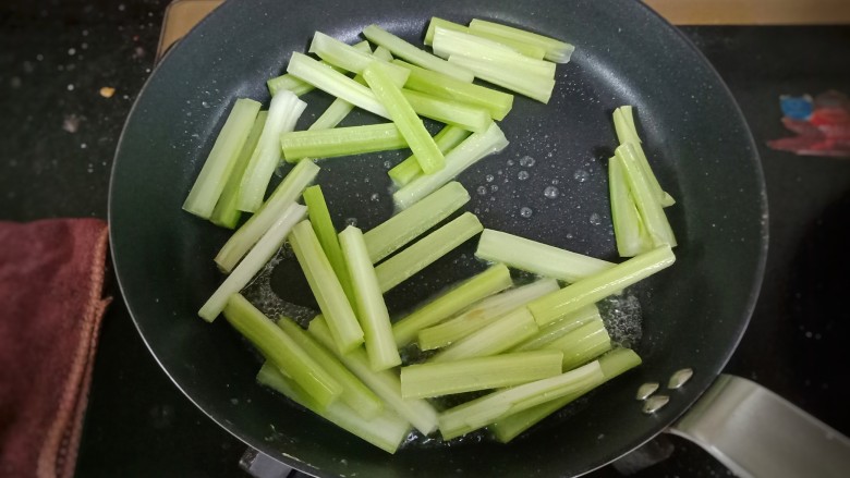 香菇芹菜炒香干,起锅热油，加入芹菜炒至变色