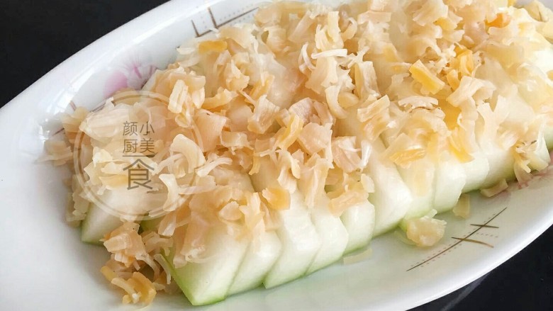 干贝蒸冬瓜,切好的冬瓜片摆在盘里,然后撒上捏碎的干贝。