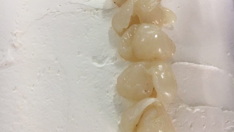 玫瑰荔枝卷,抹平在卷上,加入荔枝,卷好放冰箱定型30分钟