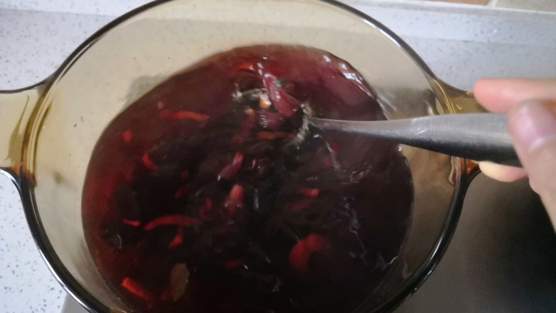 夏季消暑饮品—冰镇酸梅汤,将煮过的材料过滤出来,把酸梅汤倒入容器里放冰箱冷藏。