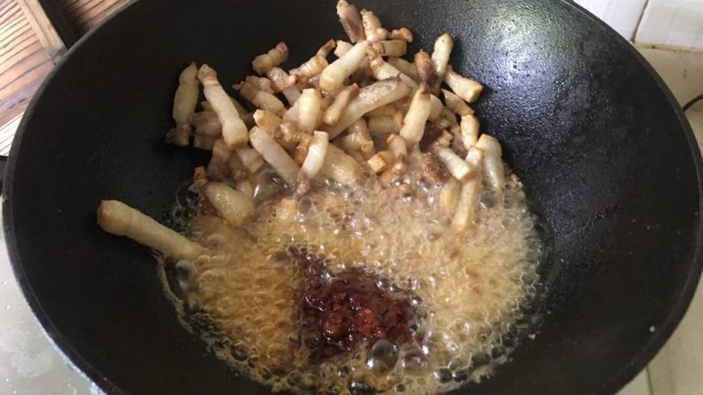 红烧猪肉面,爆油后的猪肉丁铲在一边,将蒜姜粒、郫县豆瓣、花椒、白糖等调料,一次性倒入在猪油里翻炒。