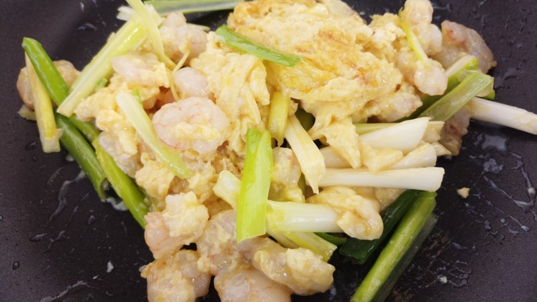 虾仁滑蛋,待鸡蛋液凝固开始翻炒,加入葱段。