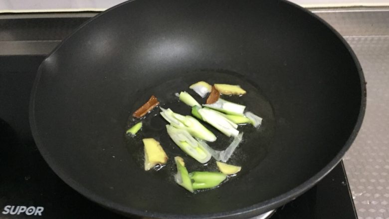 高压锅版香菇鸡,锅中倒入适量油,烧热放入葱姜,桂皮,炒香