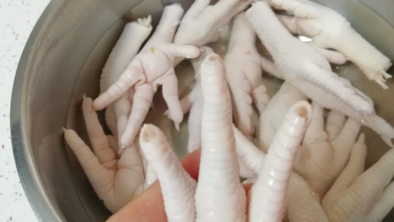 泡椒柠檬花生鸡爪,泡过的鸡爪清洗干净,剪去指甲。