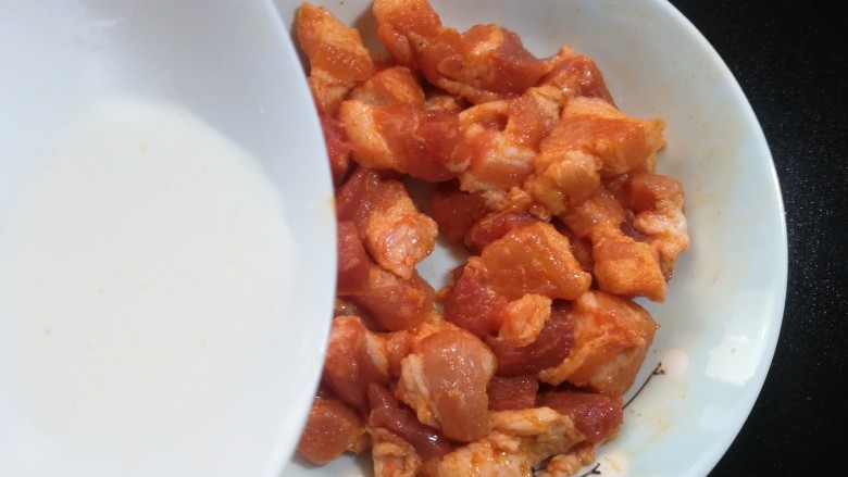 孜然烤肉串,腌制好后取出,倒入两勺水淀粉。