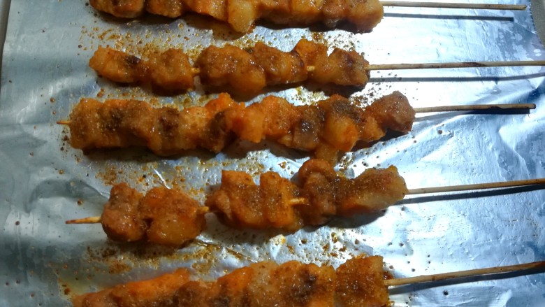 孜然烤肉串,取出翻面,再撒上孜然粉和黑椒粉,有迷迭香等调料的也可以用。