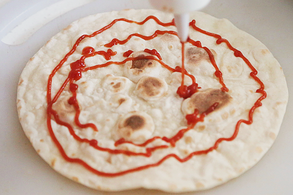 鸡胸沙茶卷饼,取一个饼皮放在案板上,挤上<a style='color:red;display:inline-block;' href='/shicai/ 699'>番茄酱</a>