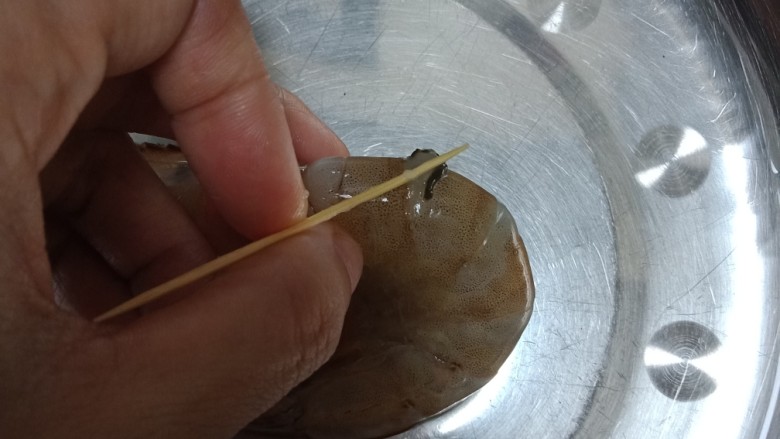 虾仁玉子豆腐,虾先去掉虾肠,在虾身的第二节的地方用牙签穿过去挑出来。就把虾肠挑出来了