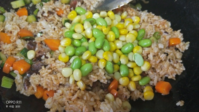 好滋味腊味菠萝炒饭,最后加入煮熟的毛豆,玉米粒和盐翻炒均匀