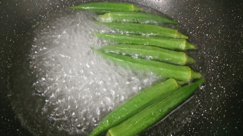 快手菜――美味又营养的鸡蛋秋葵,锅内放水烧开,放入几滴油和适量盐进去,把秋葵倒进去焯一下,这样会使秋葵颜色更翠绿。