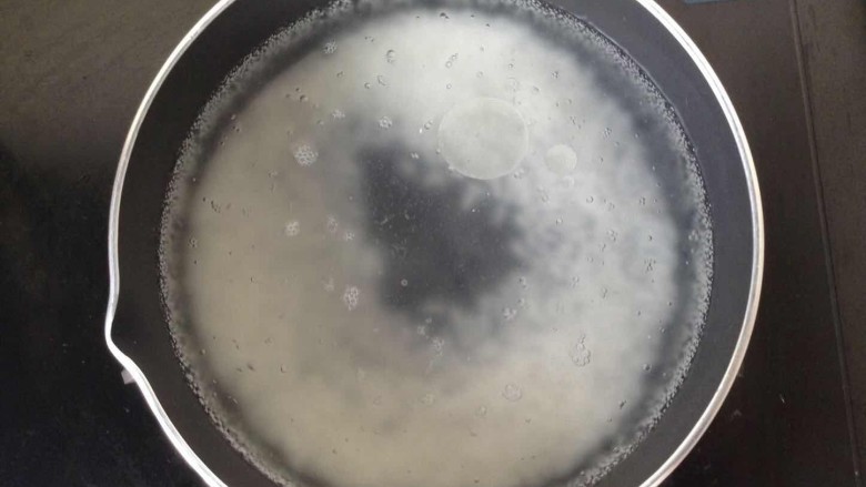 【五色靓粥】,淘洗好大米后用清水寖泡半个小时,然后倒入少许油,开始大火煮。