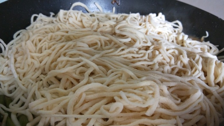 正宗手擀豆角焖面,把手擀面铺在豆角上，盖上锅盖中火焖10分