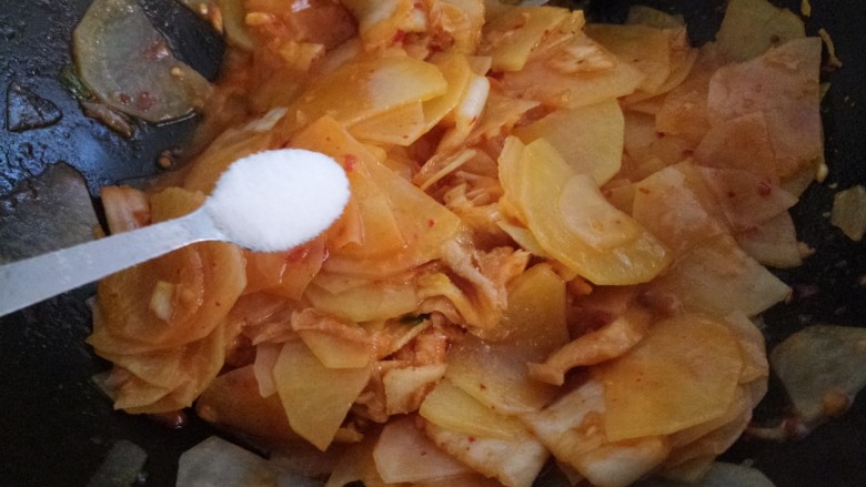 辣白菜炒土豆片,翻炒均匀,加一勺盐。