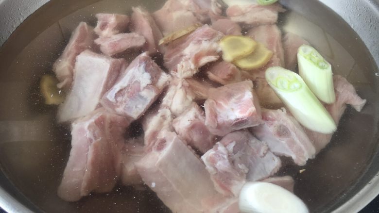 排骨炖豆角粉丝,锅里放入小肋排骨,放入凉水,加入姜片和葱段,放入2勺<a style='color:red;display:inline-block;' href='/shicai/ 894'>黄酒</a>。