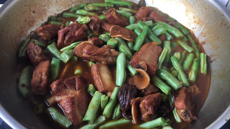 排骨炖豆角粉丝,将豆角放入炖好了排骨里,翻炒均匀,中火炖10分钟。