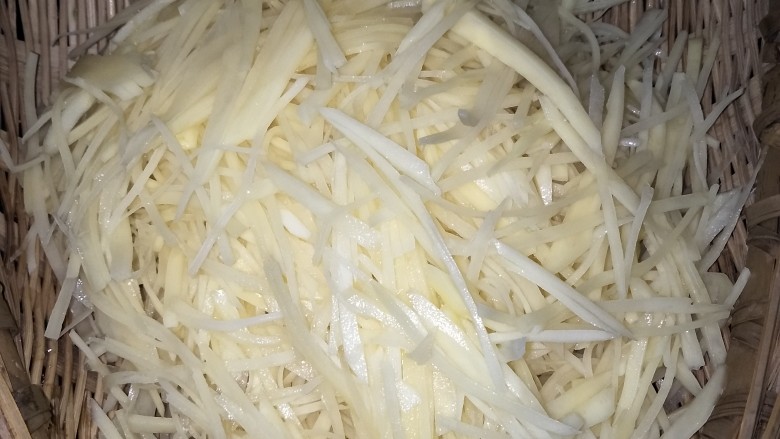 丝丝入味之酸辣土豆丝,将浸泡的土豆丝捞在漏盆里,在冷水下冲洗几遍,静置沥干