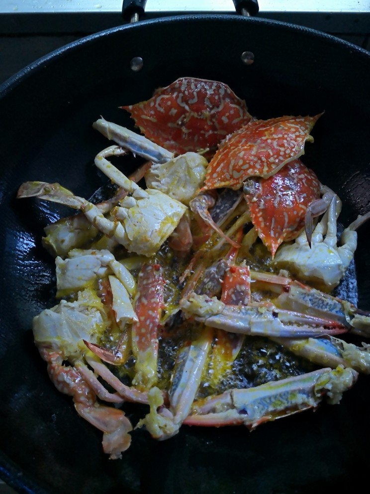兰花蟹芦笋,坐锅起油,八成热下腌制好的兰花蟹煎制出香变色