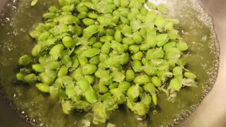 凉拌芹菜毛豆米,毛豆米倒入水中,大火焯水5分钟。