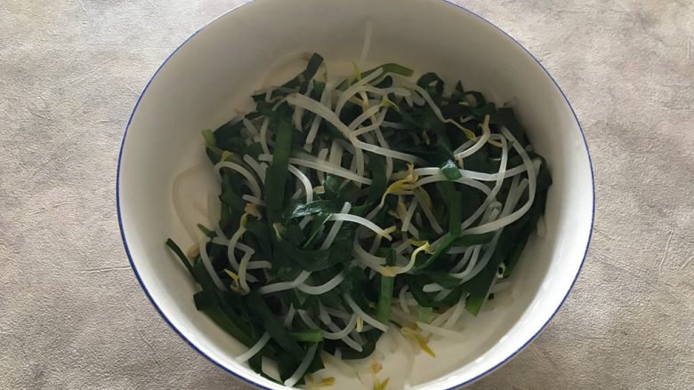 韭菜豆芽拌蛋皮,捞出煮好的韭菜和绿豆芽,控干水分