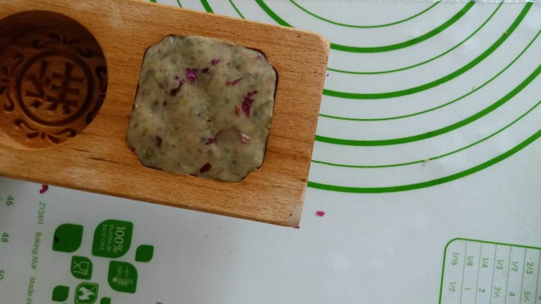 三种口味的带皮绿豆糕,取50克绿豆糕,装入模具。