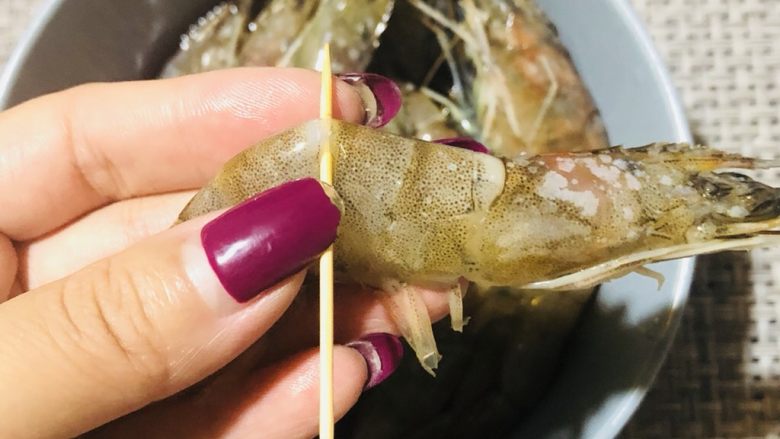 普罗旺斯风情烤虾,用牙签插入虾背部第三个关节内,挑出虾线。
