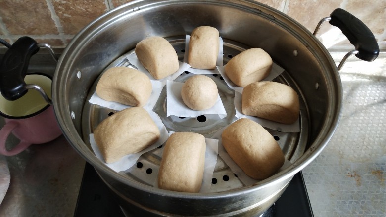 全麦馒头,蒸锅里水烧温热,均匀的放入馒头。中间就距离,盖上盖子进行发酵,大概30分钟左右即可,不用换水直接开中火蒸至15分钟左右,关火闷2分钟取出