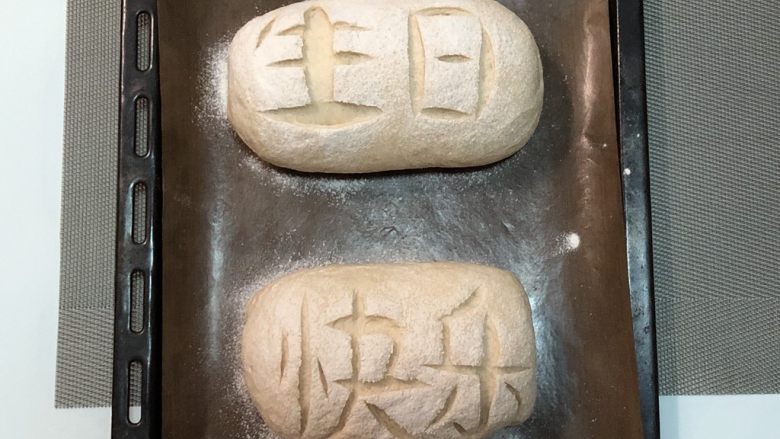 生日主题葡萄蔓越莓软欧,预热烤箱上210度下180度，底层放烤盘放一碗水制造蒸汽
发酵好面团撒粉，割字就一刀一刀的割

放入预热好的烤箱，中层，烤盘水干了，再倒半碗凉水，7分钟撤走烤盘，继续烤10-12分钟即可，具体根据自己烤箱脾气
