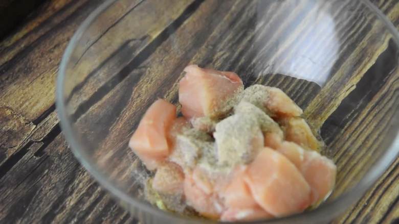 在家就能做劲脆鸡米花,一样的好吃且更加健康,鸡胸肉切丁放入碗中,加入胡椒粉、料酒、盐,搅拌均匀后腌制15分钟。