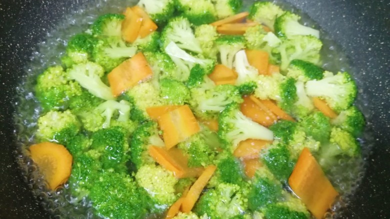 西兰花炒虾仁,锅里放水烧开,加入一点盐和食用油,下入西兰花和胡萝卜焯水至断生捞出过凉水,沥干水分备用。