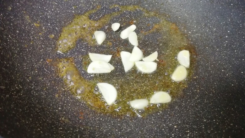 西兰花炒虾仁,锅底留余油,下入蒜片炒香。