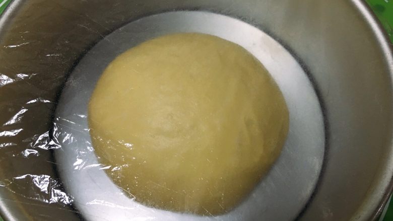 原味吐司,整理一下,滚圆放入模具,盖上保鲜膜。