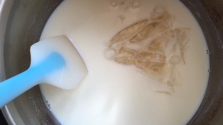 Hello kitty蜜豆牛奶冻,将牛奶坐冷水降温至不烫手的热度。泡软的吉利丁片过滤掉水份,放入温热牛奶中搅拌均匀,牛奶的余温会将吉利丁融化